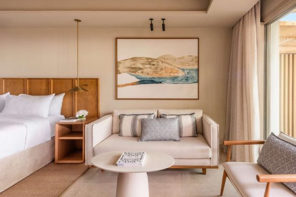 Chambre d'hôtel prise de l'intérieur avec un tableau au centre de l'image, le lit à gauche ainsi que la porte de la terrasse à droite.